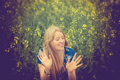 Happy young woman standing on field