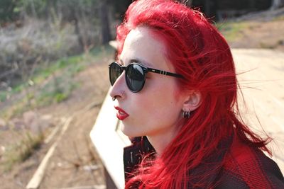 Young woman with dyed hair looking away outdoors