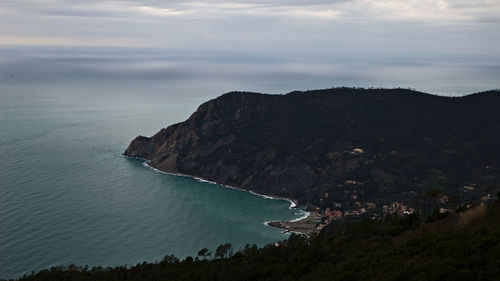 High angle view of sea and mountains against sky