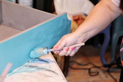 Cropped image of worker painting wood