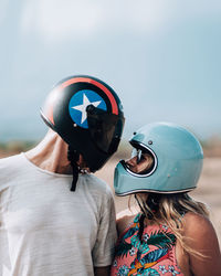 Rear view of man and woman wearing mask against sky