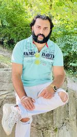 Portrait of young woman sitting on field