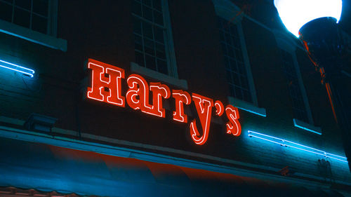 Low angle view of illuminated information sign at night