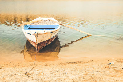 Boat moored on shore at beach