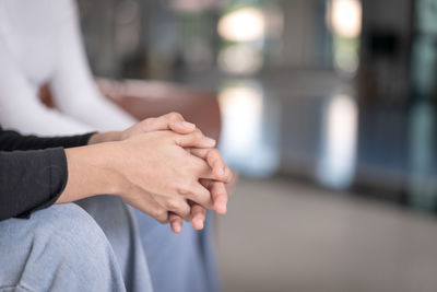 Midsection of couple holding hands