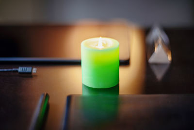 Close-up of illuminated candle on table