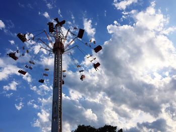 Low angle view of chain swing ride against sky