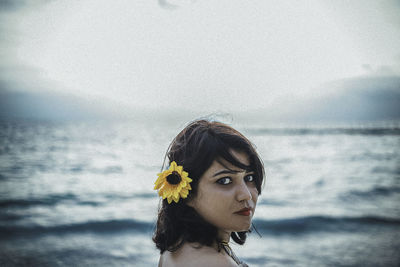 Portrait of young woman against sea