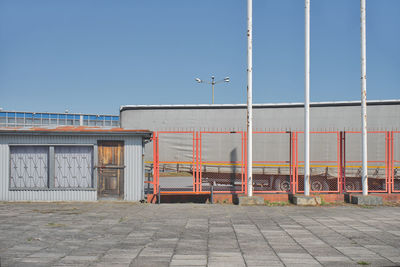 Street by building against clear blue sky