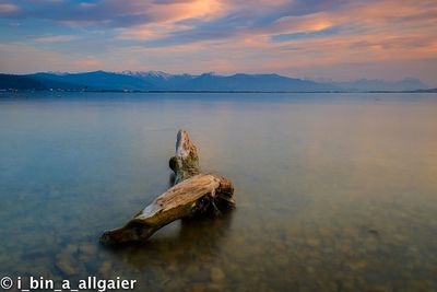 Scenic view of lake against sky at sunset