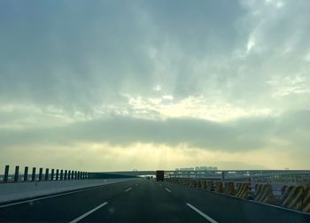 Empty road against sky during sunset