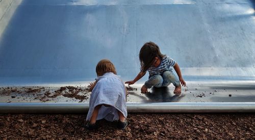 Rear view of mother and daughter in water