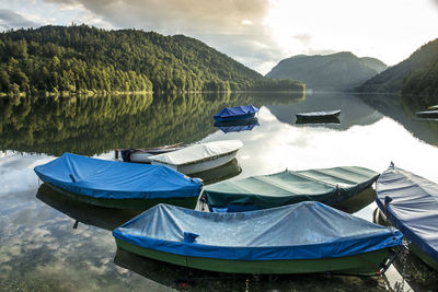 Boats moored on lake against sky