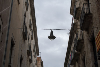 Low angle view of light bulbs hanging against sky