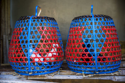 Birds in cages on table against wall