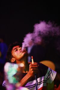 Young man smoking hookah in bar