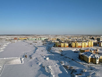 Buildings in city against clear blue sky