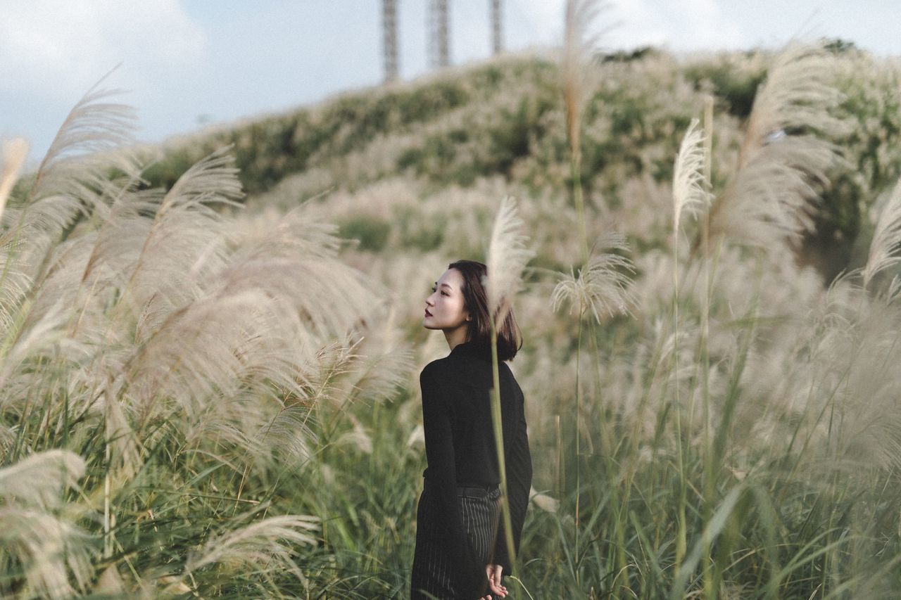 young adult, plant, one person, young women, land, leisure activity, growth, field, three quarter length, standing, real people, nature, lifestyles, casual clothing, day, grass, women, adult, front view, beautiful woman, wind, outdoors