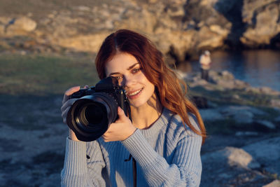 Portrait of young woman photographing camera