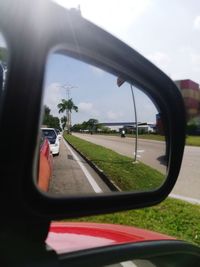 Reflection of man on side-view mirror of car