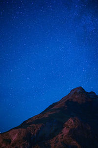 Low angle view of mountain against blue sky