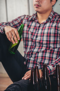 Midsection of man holding ice cream in bottle