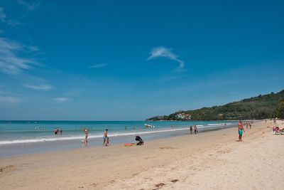 Group of people on beach against sky