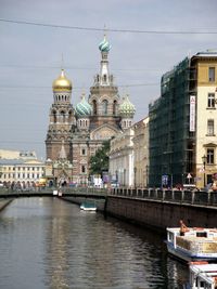 River and church of savior on blood against sky in city