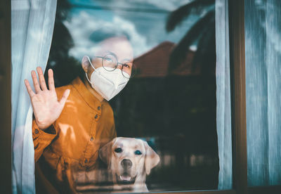 Woman with dog siting by window