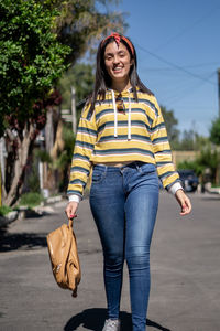 Student girl in a trendy clothes crossing the road. stylish hipster girl wearing oversized 