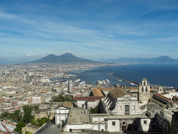 High angle view of townscape by sea against sky