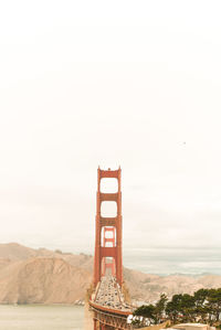 Golden gate bridge over river in city against sky