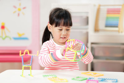 Cute girl having food on table