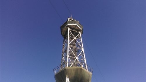 Low angle view of communications tower against clear blue sky