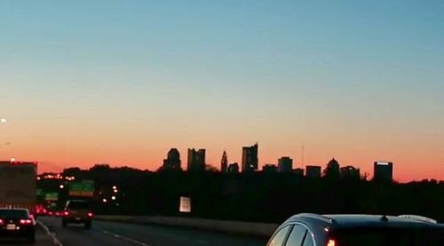 Cars on road against sky during sunset