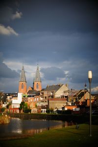 River by buildings in city against sky