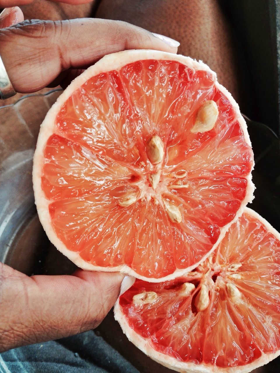 food and drink, freshness, food, fruit, healthy eating, person, red, holding, close-up, part of, cropped, indoors, slice, juicy, orange color, cross section, unrecognizable person