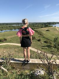 Rear view of woman on landscape against sky