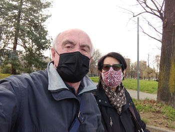 Portrait of friends standing in park during winter