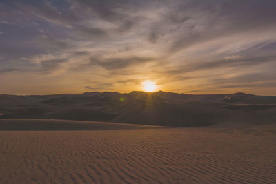 Rippled sand and sand dunes at sunset