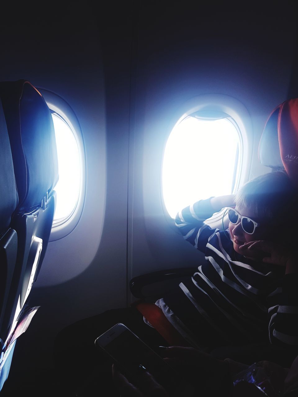 MAN SITTING BY AIRPLANE WINDOW IN BUS