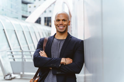 Portrait of young man standing against wall