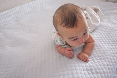 High angle view of baby girl lying on bed