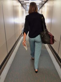 Rear view of woman standing in corridor