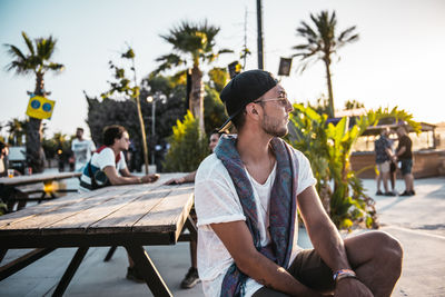 Man sitting on table against trees