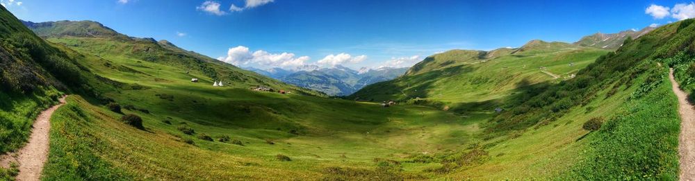 Panoramic view of green landscape against sky