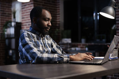 Young man using laptop at table