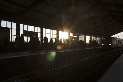 Silhouette railroad station platform against sky