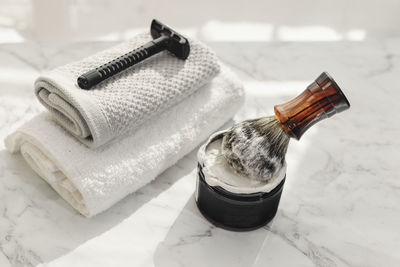 Close-up of shaving equipment on marble table