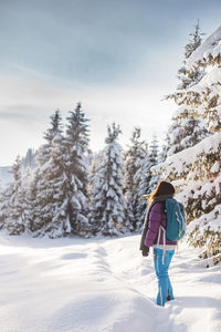 Rear view of man skiing on snow covered landscape